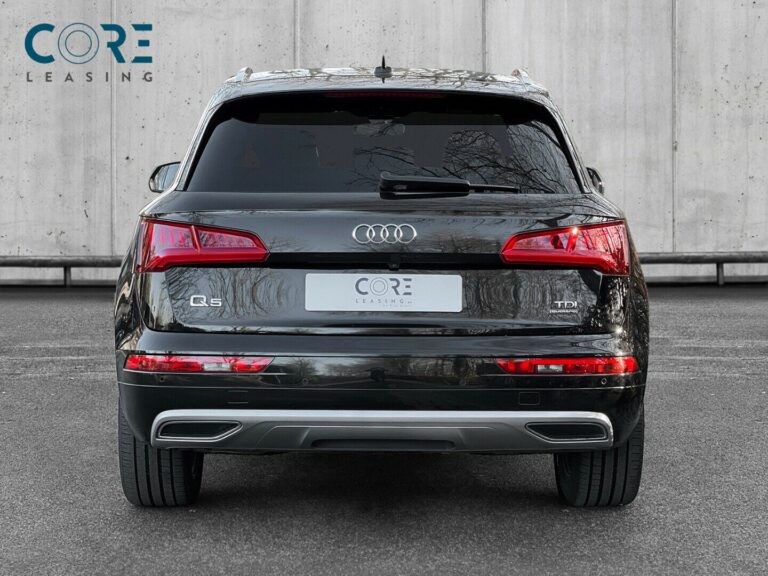 Sortmetal Audi Q5 TDi 190 S-line quattro S-tr. fra 2017 parkeret foran en betonmur. CORE Leasing A/S er eksperter i Audi leasing.