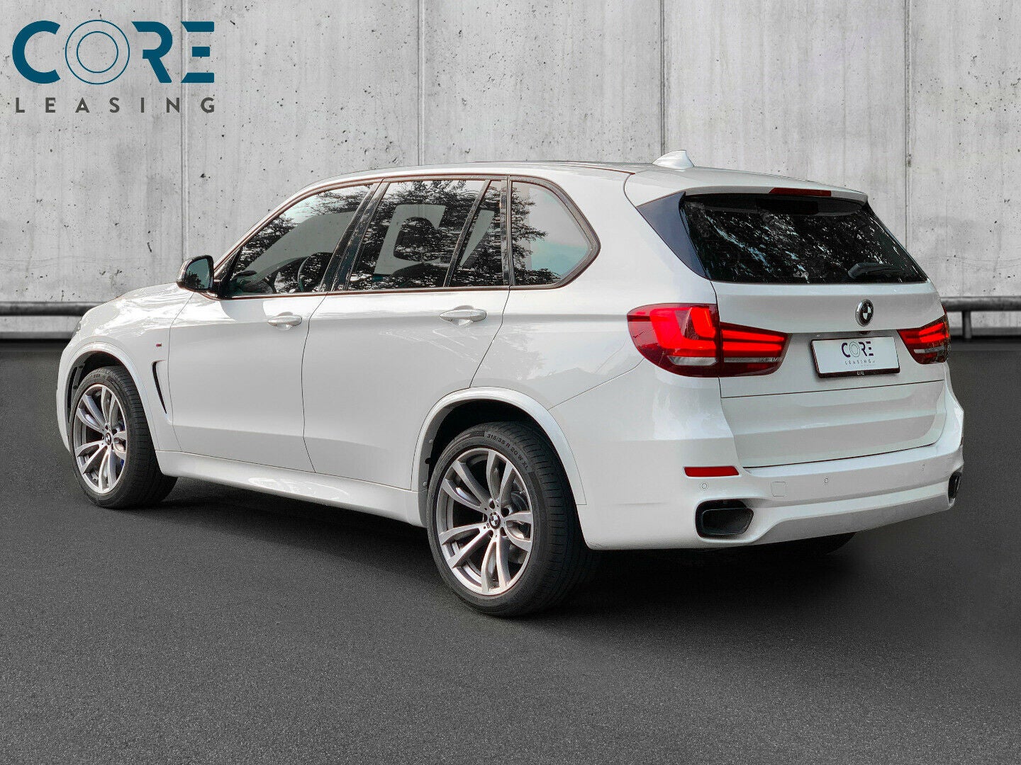 Hvidmetal BMW X5 M50d xDrive aut. fra 2014 parkeret foran en betonmur. CORE Leasing A/S er eksperter i BMW leasing.