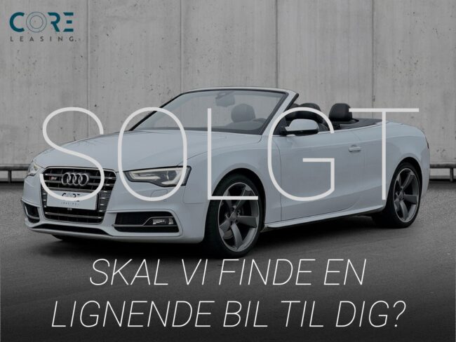 Hvidmetal Audi S5 TFSi Cabriolet quattro S-tr. fra 2012 parkeret foran en betonmur. CORE Leasing A/S er eksperter i Audi leasing.