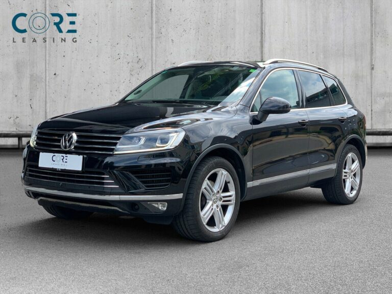Sortmetal VW Touareg V6 TDi 262 Tiptr. 4Motion fra 2014 parkeret foran en betonmur. CORE Leasing A/S er eksperter i VW leasing.