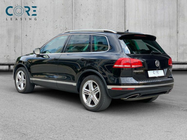 Sortmetal VW Touareg V6 TDi 262 Tiptr. 4Motion fra 2014 parkeret foran en betonmur. CORE Leasing A/S er eksperter i VW leasing.