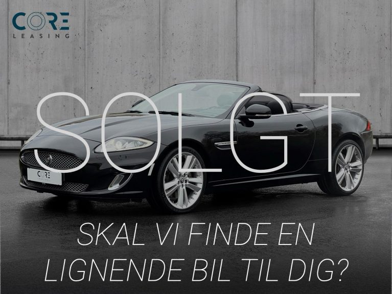 Sortmetal Jaguar XK V8 Convertible aut. fra 2013 parkeret foran en betonmur. CORE Leasing A/S er eksperter i Jaguar leasing.