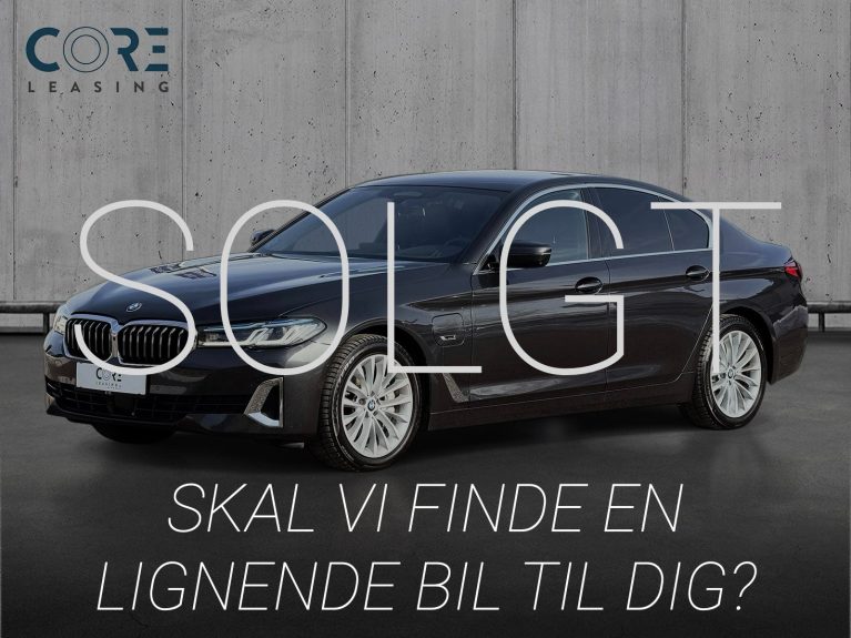 Gråmetal BMW 545e Luxury Line xDrive aut. fra 2021 parkeret foran en betonmur. CORE Leasing A/S er eksperter i BMW leasing.