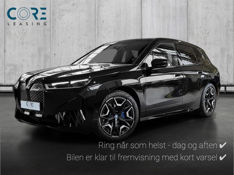 Sortmetal BMW iX xDrive50 Supercharged fra 2024 parkeret foran en betonmur. CORE Leasing A/S er eksperter i BMW leasing.