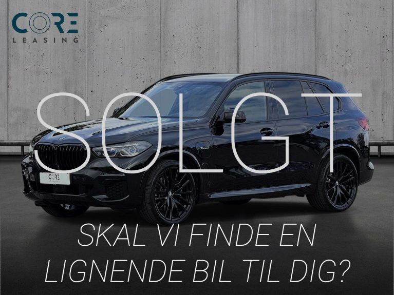 Sortmetal BMW X5 xDrive45e M-Sport aut. fra 2023 parkeret foran en betonmur. CORE Leasing A/S er eksperter i BMW leasing.