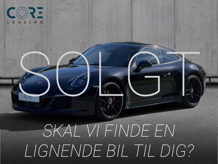 Sortmetal Porsche 911 Carrera 4 GTS Coupé PDK fra 2017 parkeret foran en betonmur. CORE Leasing A/S er eksperter i Porsche leasing.