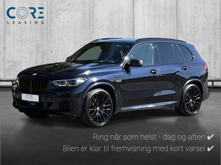 Sortmetal BMW X5 xDrive45e M-Sport aut. fra 2022 parkeret foran en betonmur. CORE Leasing A/S er eksperter i BMW leasing.