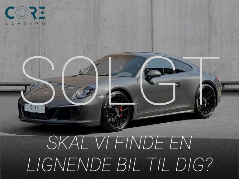 Gråmetal Porsche 911 Carrera 4 GTS Coupé PDK fra 2018 parkeret foran en betonmur. CORE Leasing A/S er eksperter i Porsche leasing.