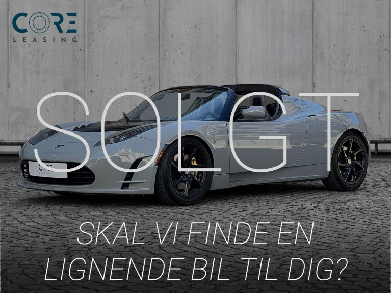 Gråmetal Tesla Roadster  fra 2010 parkeret foran en betonmur. CORE Leasing A/S er eksperter i Tesla leasing.