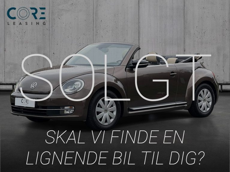 Brunmetal VW The Beetle TSi 150 Sport Cabriolet DSG fra 2015 parkeret foran en betonmur. CORE Leasing A/S er eksperter i VW leasing.