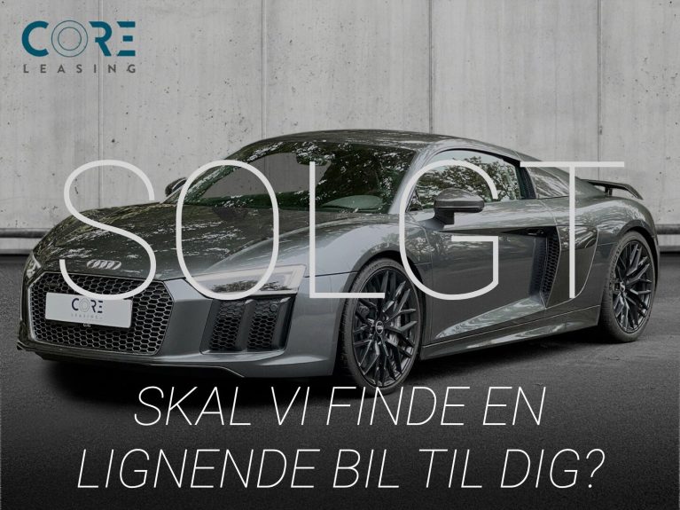 Gråmetal Audi R8 FSi Plus Coupé quattro S-tr. fra 2016 parkeret foran en betonmur. CORE Leasing A/S er eksperter i Audi leasing.