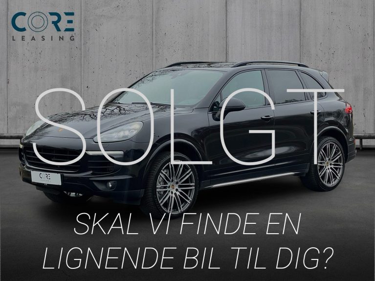 Sortmetal Porsche Cayenne S D Platinum Tiptr. fra 2018 parkeret foran en betonmur. CORE Leasing A/S er eksperter i Porsche leasing.