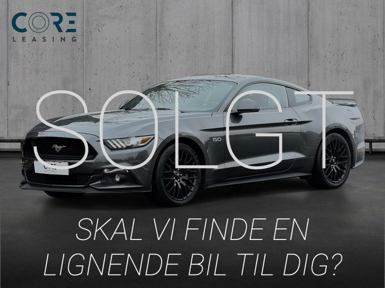 Gråmetal Ford Mustang V8 GT Fastback aut. fra 2015 parkeret foran en betonmur. CORE Leasing A/S er eksperter i Ford leasing.