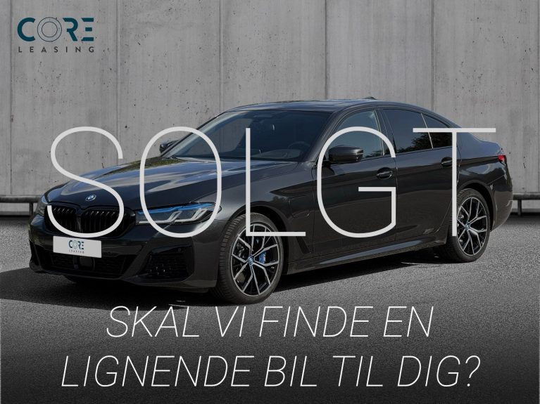Gråmetal BMW 545e M-Sport xDrive aut. fra 2022 parkeret foran en betonmur. CORE Leasing A/S er eksperter i BMW leasing.